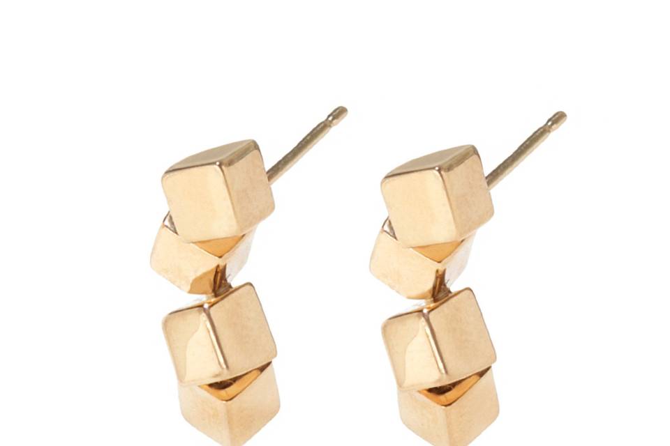 These organic earrings from Tilda Biehn are detailed by hand in 14 karat yellow gold. Four solid cubes rest in a falling formation that create depth and appear to be floating. These earrings measure 11/16
