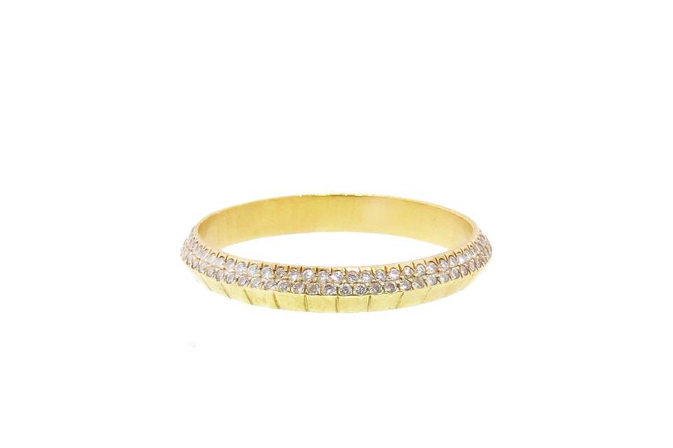 This thin band from Monique Pean is handmade in recycled 18 karat yellow gold and is detailed with white diamonds on one side. The carat weight is .40 carats and the band measures 3mm wide.