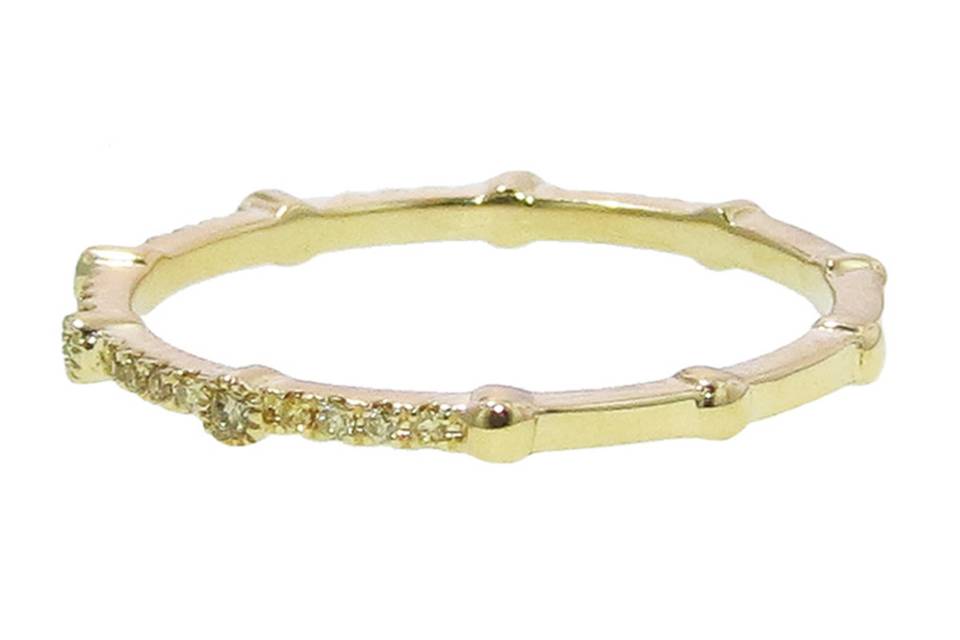 Perfect for stacking! This micro band from Hildago is composed of 18 karat yellow gold, and features a thin row of bright yellow diamonds set half way around that total .12cts.