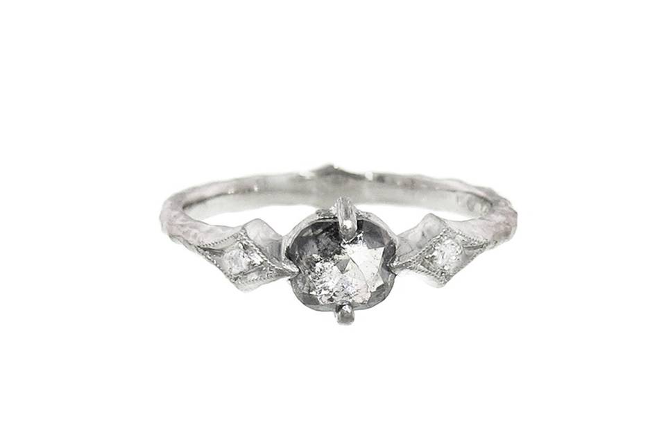 This sophisticated ring from Cathy Waterman is a knockout! Set in platinum, a .53 carat black and white diamond is prong set and reveals natural tones of black, white and hints of clear. The diamond is rests on a lightly hammered band that is finished with two thorn ends each detailed with a sparkling diamond.