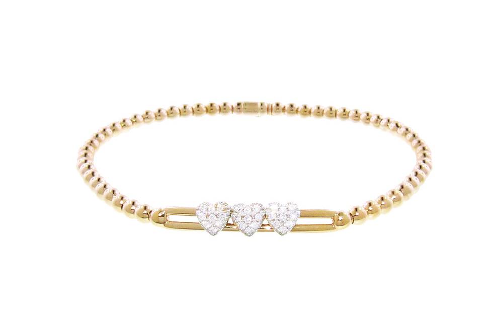 This romantic bracelet from Hulchi Belluni is perfect for stacking! This bracelet is set in 18 karat yellow gold and features three delicate hearts detailed in diamonds that slide across two bars. With a feminine design this bracelet is finished on a stretchy bracelet with polished yellow gold beads. Ideal for most wrists. Diamonds share a carat weight of .22 cts.