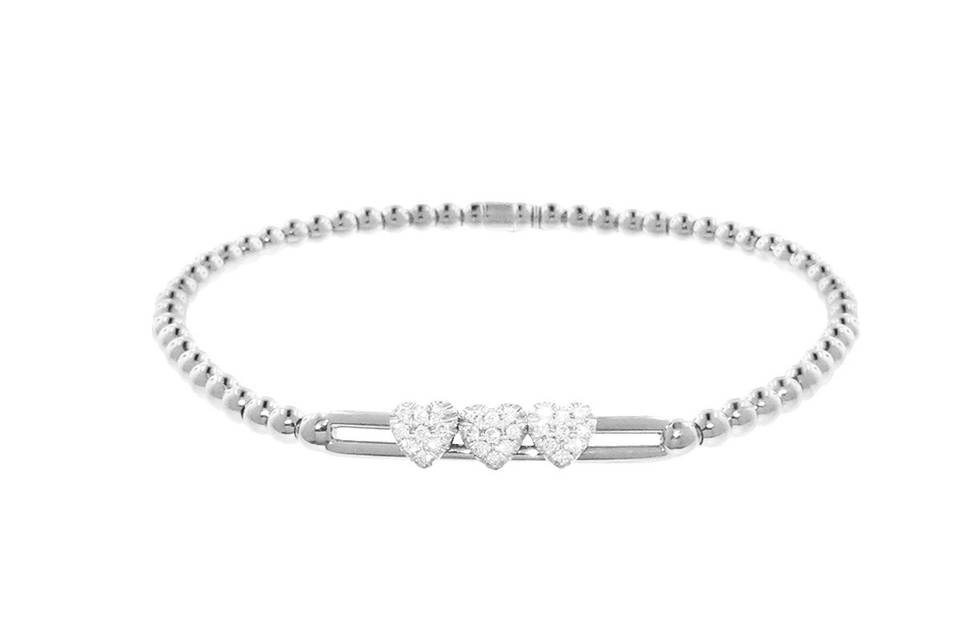 This fun bracelet from Hulchi Belluni has a lovely energy! This bracelet is set in 18 karat white gold and features three delicate hearts detailed in diamonds that slide across two bars. With a feminine design this bracelet is finished on a stretchy bracelet with polished white gold beads. Ideal for most wrists. Diamonds share a carat weight of .22 cts.
