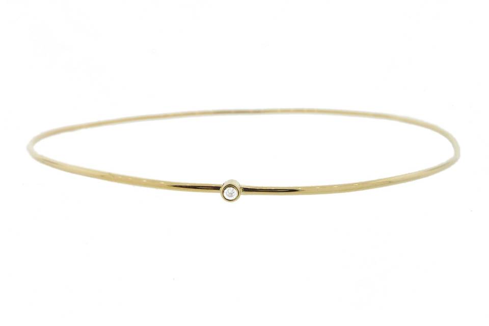 Simple and stunning! This thin bangle from Jennifer Meyer is composed of 18 karat gold, a round wire with a single bezel set diamond. Measures 2 1/2
