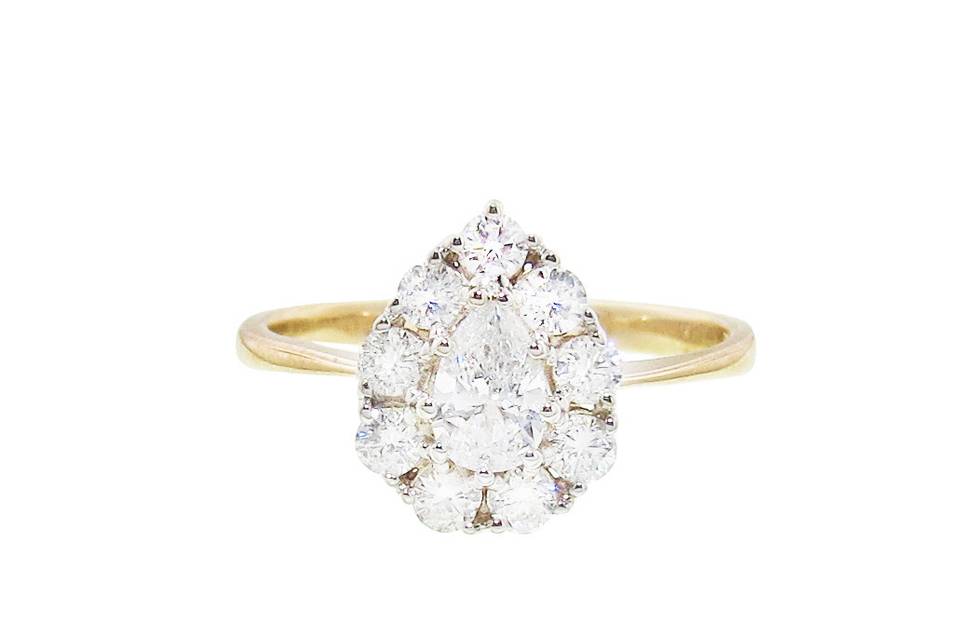 An absolute stunner from Lori McLean, this timeless ring will sparkle in every room. Set in 14 karat white gold, this ring features a .32 carat pear diamond that is D/VS1. The pear diamond is framed in dazzling .82 carats worth of G/I SI diamonds. Each diamond is individually prong set. Finished on a thin 14 karat gold band.