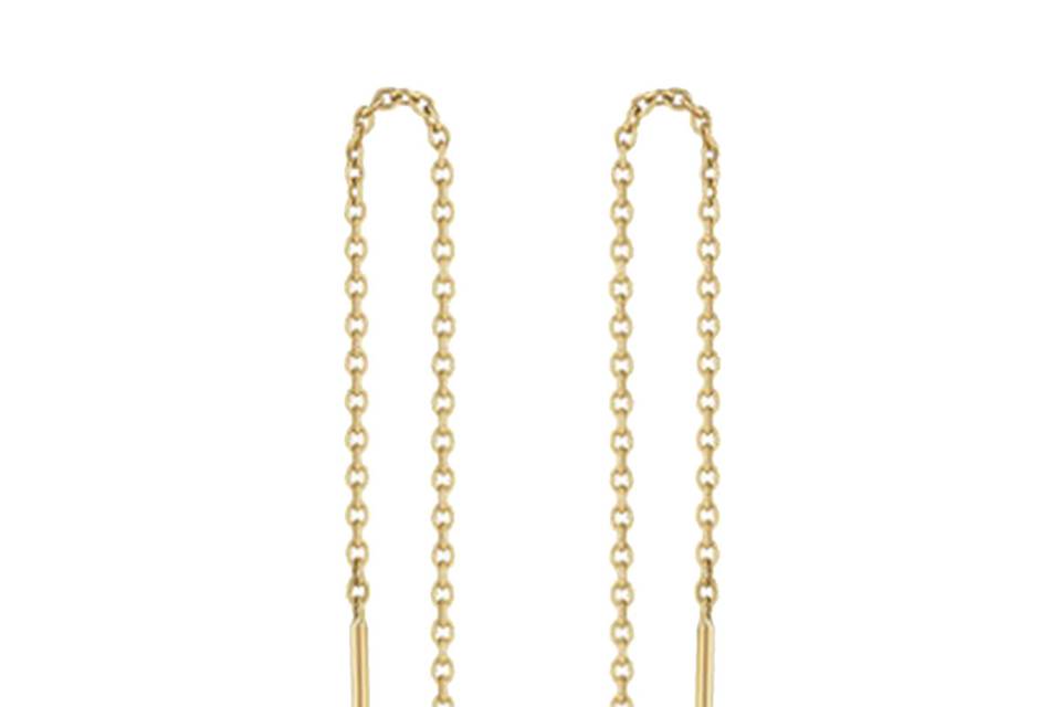 These trendsetting, thread through, statement earrings from Minor Obsessions are the epitome of contemporary chic. Crafted in 10 karat gold, a bezel set diamond dangles at the end of fine chaining. The earrings have a length of 3