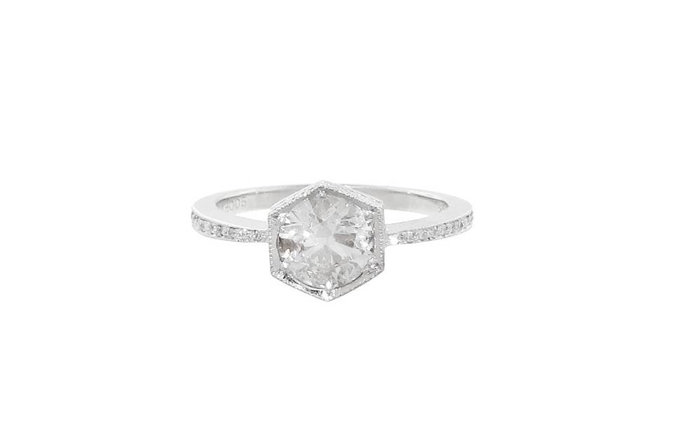 This elegant hexagonal ring from Cathy Waterman has an etched milgrain setting in platinum and features a black and white diamond center with a carat weight of 1.03 carats. The stone rests on a thin band with diamonds set halfway around the band and it is finished with Cathy's signature hammered detail.