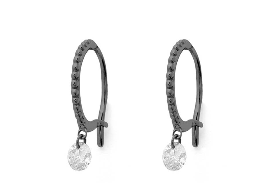 These stunning earrings from Raphaele Canot will enhance your everyday looks. These hoops are set in 18 karat blackened gold and feature a beaded motif that adds a vintage edge to these hoops. Accented with a large white diamond that dangles freely from the hoops. The diamonds total .20 carats. Measure 3/8