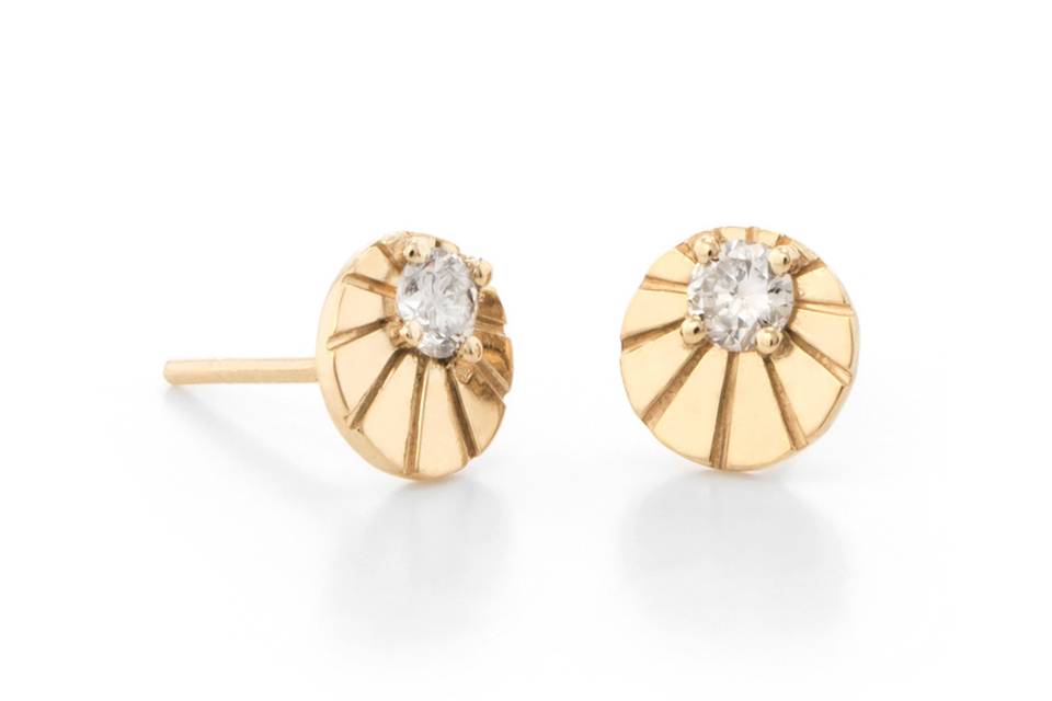 These gorgeous earrings from designer Larisa Laivins make a great multi-stud addition. These stud earrings are detailed by hand in 18 karat gold and feature an intricately etched gold circle. Both studs are detailed with a prong set sparkling white diamond. These circle studs measure 5/16