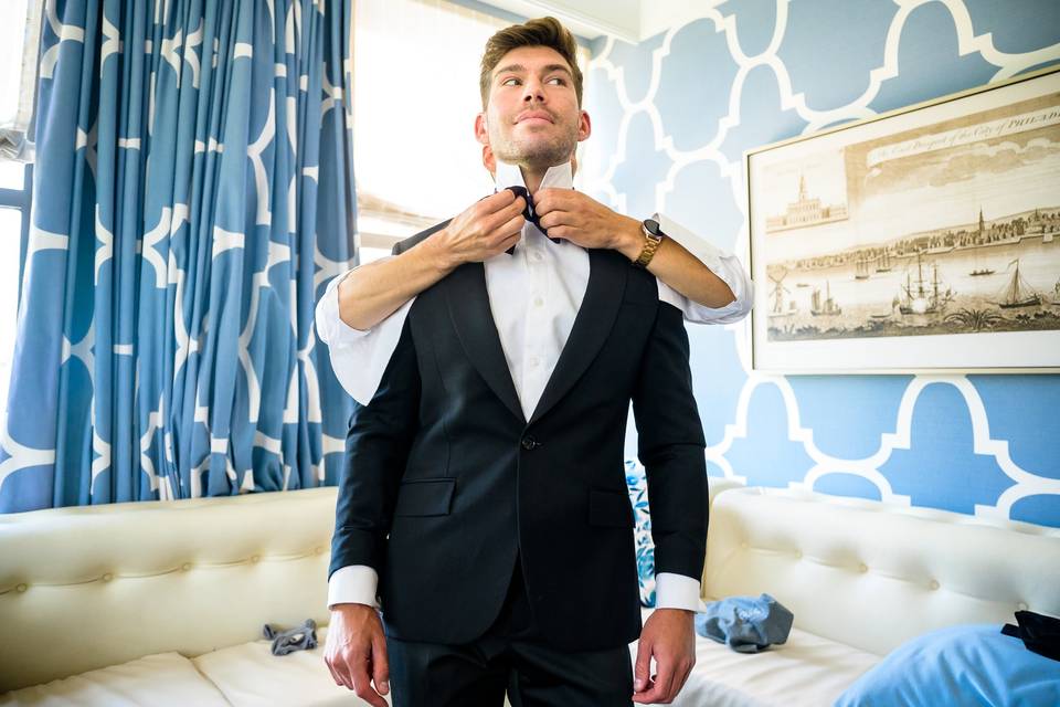 Groom fixing groomsman bowtie