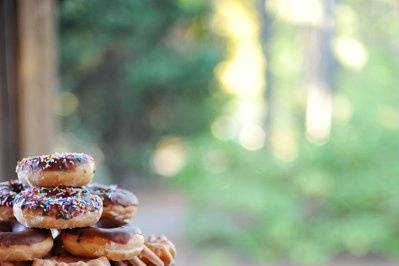 Delicious Krispy Kreme doughnut groom's cake atop an antique suitcase - Pavilion at Aldridge Gardens, Birmingham