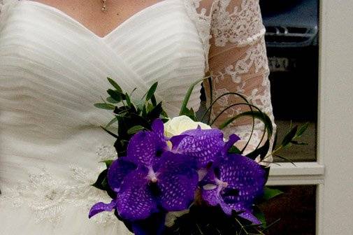 A dramatic bridal bouquet with big purple orchids and white English roses.