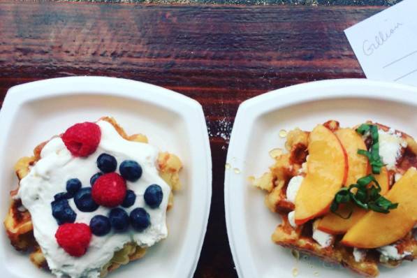 Left: Liège waffle with Lemon Curd, House-Made Whipped Cream, Strawberries, and Blueberries.Right: Liège waffle with Clockshadow Creamery Quark Cheese, Fresh Peaches, Basil, and Honey.