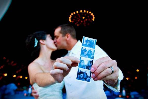 Newlyweds kissing and holding their film strip