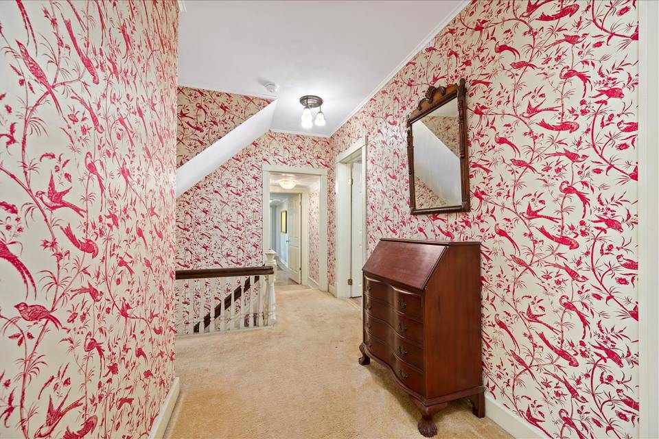 Upstairs hallway with red wallpaper