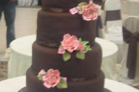 This cake was for a bride who wanted to be a little non-traditional.  She chose a Neopolitian cake with chocolate fondant and hand made flowers.  She loved the pink roses so much that she gave one to each of her bridal party members!