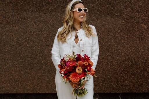 Wearing shades and holding bouquet