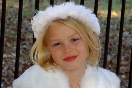 Look at this cute little flower girl! She is having a blast and looks beautiful doing it. She is wearing our faux fur head ring and bolero jacket!