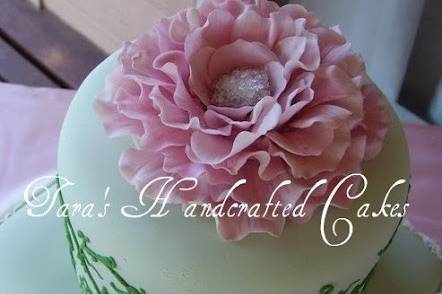 Wedding cake design using elements from invitations. Hand sculpted fantasy flower topper resembles the flower worn in the brides hair.