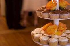 multi tier cupcake display with small top cake for couple to cut or save.