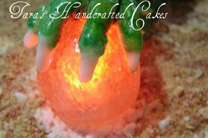 Hand sculpted dragon cake with pulled sugar fire and molded glass orb in his claw that lit up.