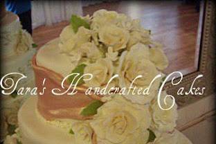 Gum paste roses and leaves in several sizes and gum paste stephanotis with edible pearl centers.
Piped floral garland on sides of cake.