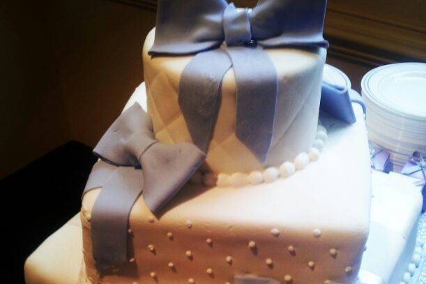 This three tiered lady was covered in fondant and pearlized, hand painted stripes were added to the bottom tier.The middle tier has edible pearls so carefully put in place, and the top finished in a quilted pattern. Lavender fondant bows finished off the surprise held inside.