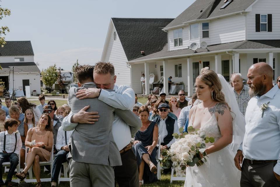 Bride's father hugging groom