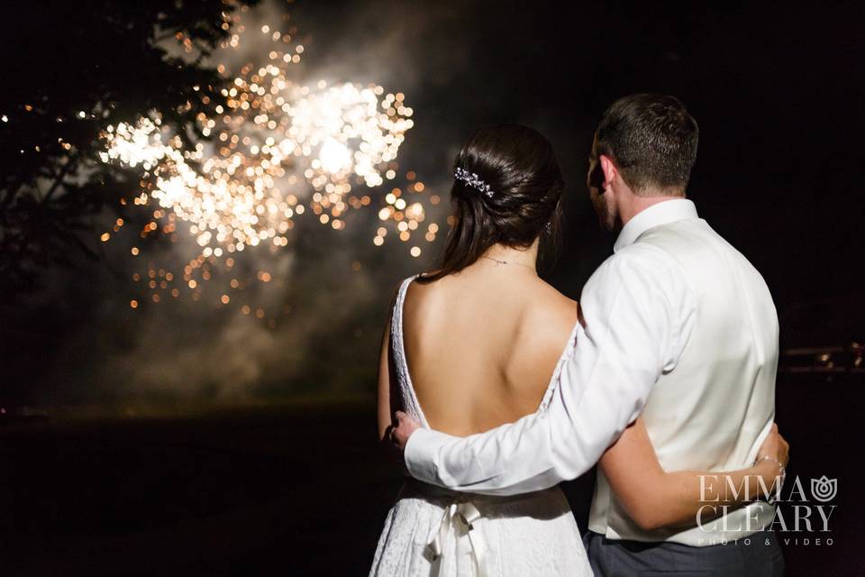 A joyful bride and groom observe the fireworks display designed just for them