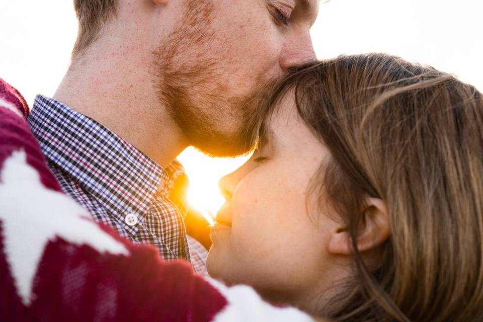 Couple kiss girl on forehead