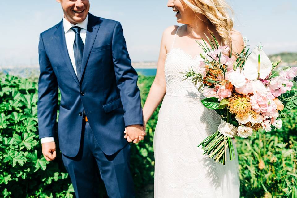 Couple holding hands with a bouquet