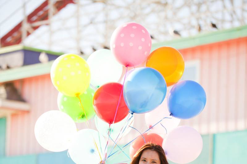 Santa Cruz beach boardwalk engagement session with cotton candy and balloons