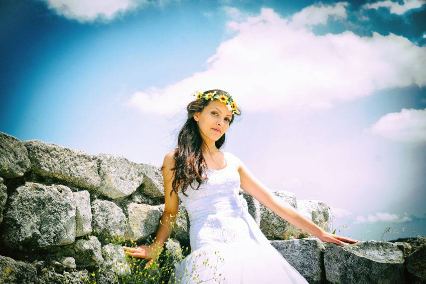 Bride stands against a rock wall