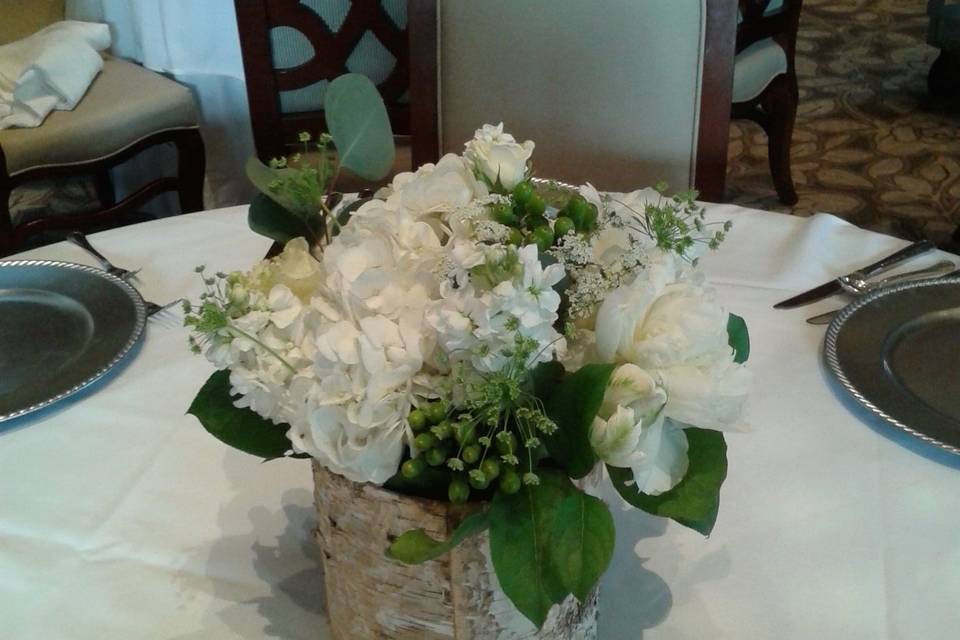 Low all white assorted flowers in birch cylinder centerpiece