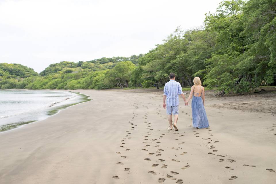 Couple walking hand-in-hand on beach