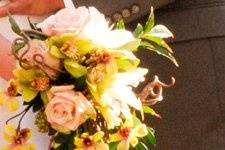 Cascade bouquet featurnig Sahara roses, ivory lilies, gold/green orchids, with Jasmine and Kiwi vine.