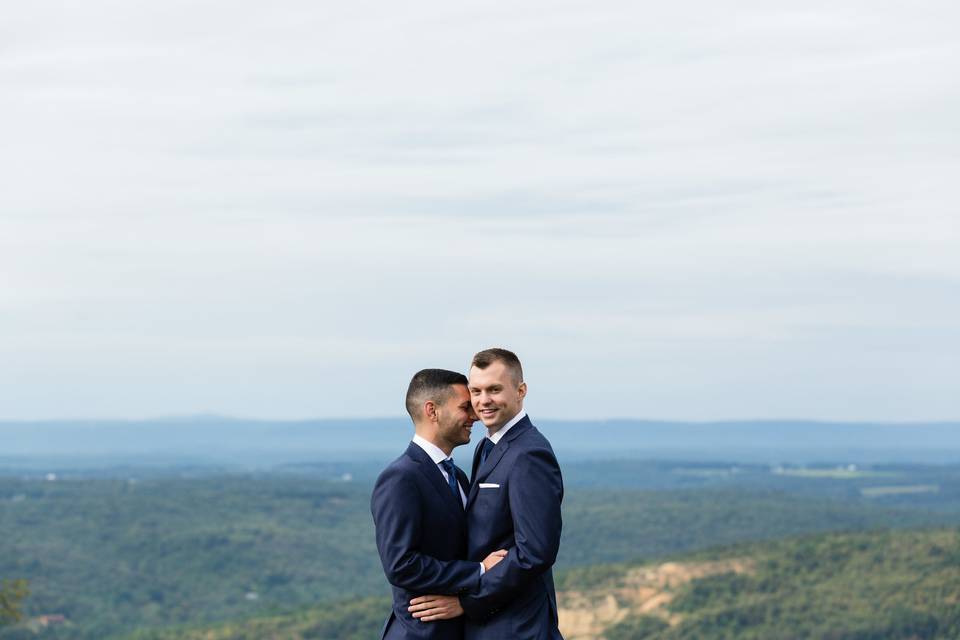 Happy couple embrace above the valley