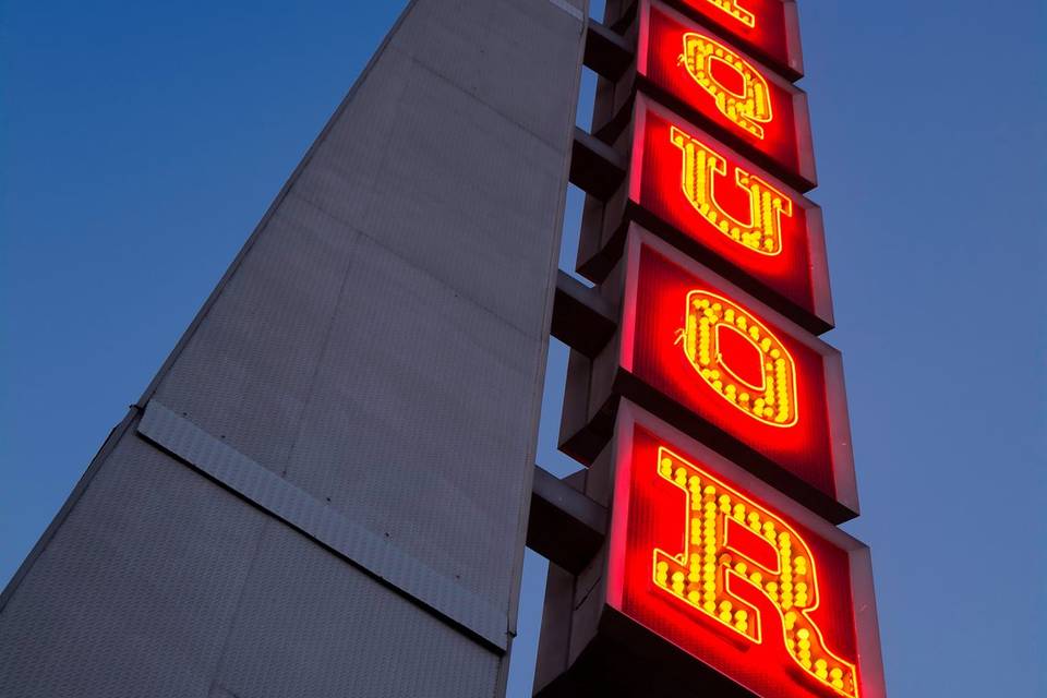 Lit up steel sign at night