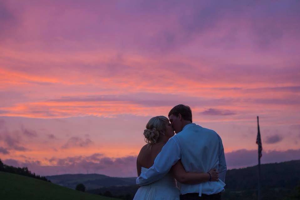 Newlyweds kissing at sunset