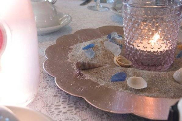 Sand, shells, vintage votives on lace tablecloths reflected the seashore theme.