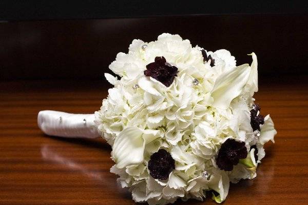 Chocolate cosmos, white calla lillies, and white hydrangeas accented with bouquet jewels