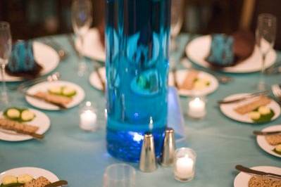 Blue hydrangeas and chocolate cosmos in cylinder vase filled with aquamarine color water