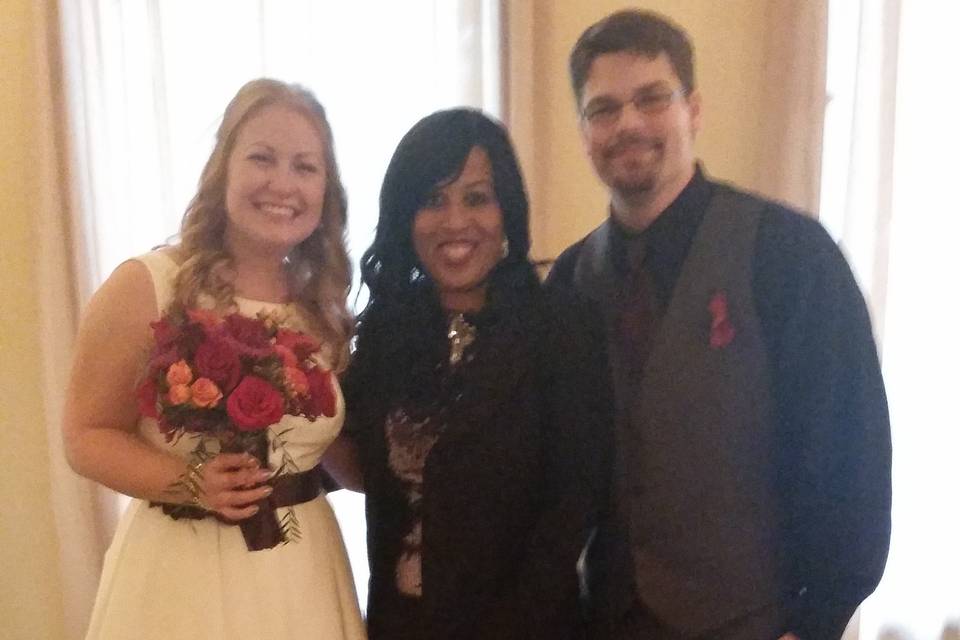 Newlywed couple and the wedding officiant