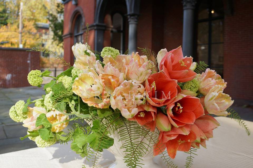 Grace Kim Floral & Event Design- orange centerpiece: amaryllis, parrot tulips, viburnum, geranium, umbrella fern