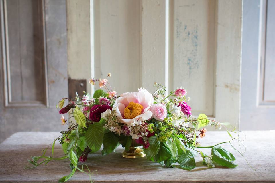 Low compote centerpiece with spring seasonal flowers