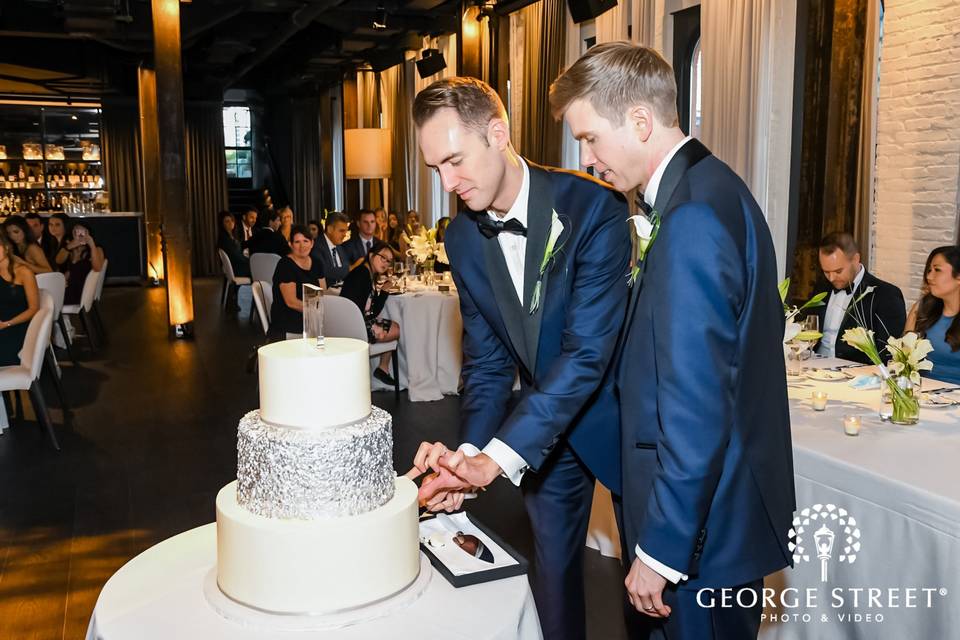 Grooms cutting wedding cake