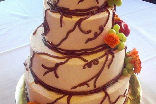 Vines, fruit and flowers.  Buttercream covered cake with fresh fruit and flowers.