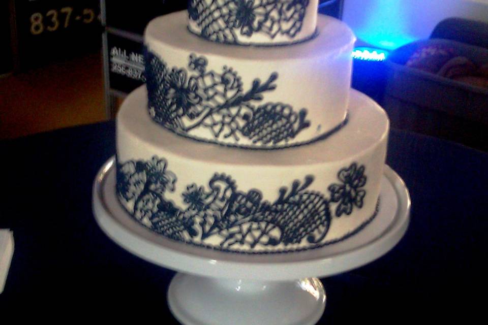 Buttercream covered cake with hand-piped lace design.
