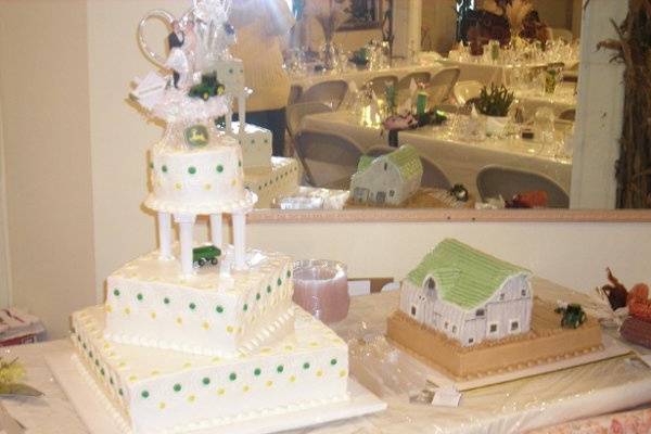 Country loving wedding cake with John Deere colors and a groom's cake depicting the aging barn on the couple's farm.