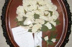 white roses, boutonniere, invitation and white pearls displayed down stem