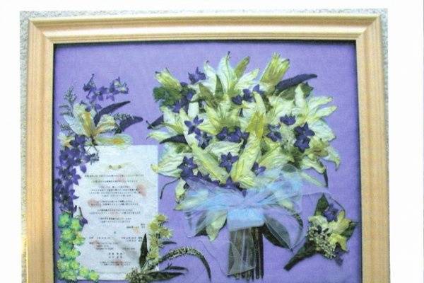 The bride's bouquet, the groom's boutonniere and the wedding invitation surrounded by reception flowers